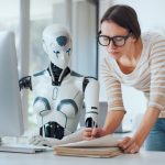 Eine Frau und KI als Roboter arbeiten zusammen im Büro.