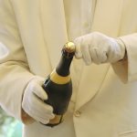 Butler öffnet eine Champagnerflasche